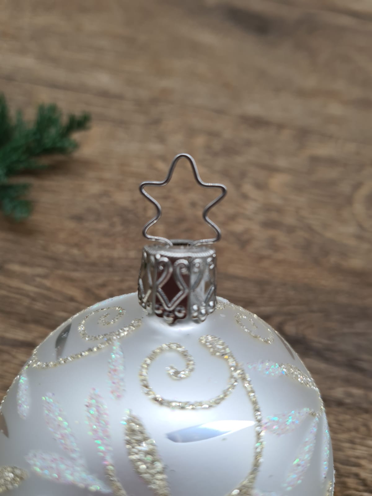 Mouth-blown silver bauble with leaves in glitter paint
