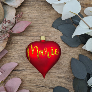 Red heart-shaped glass Christmas bauble with white text