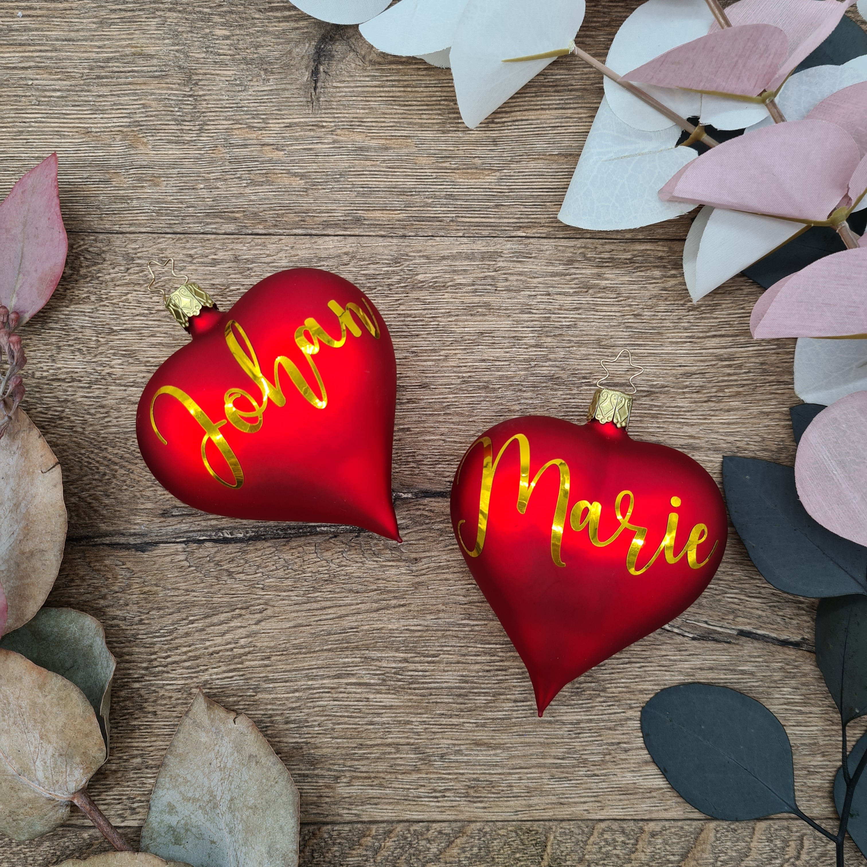Red heart-shaped glass Christmas bauble with white text