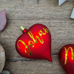 Load image into Gallery viewer, Red heart-shaped glass Christmas bauble with white text
