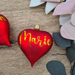 Load image into Gallery viewer, Red heart-shaped glass Christmas bauble with white text
