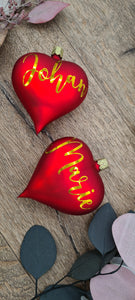 Set of 2 red heart-shaped glass Christmas balls with white text