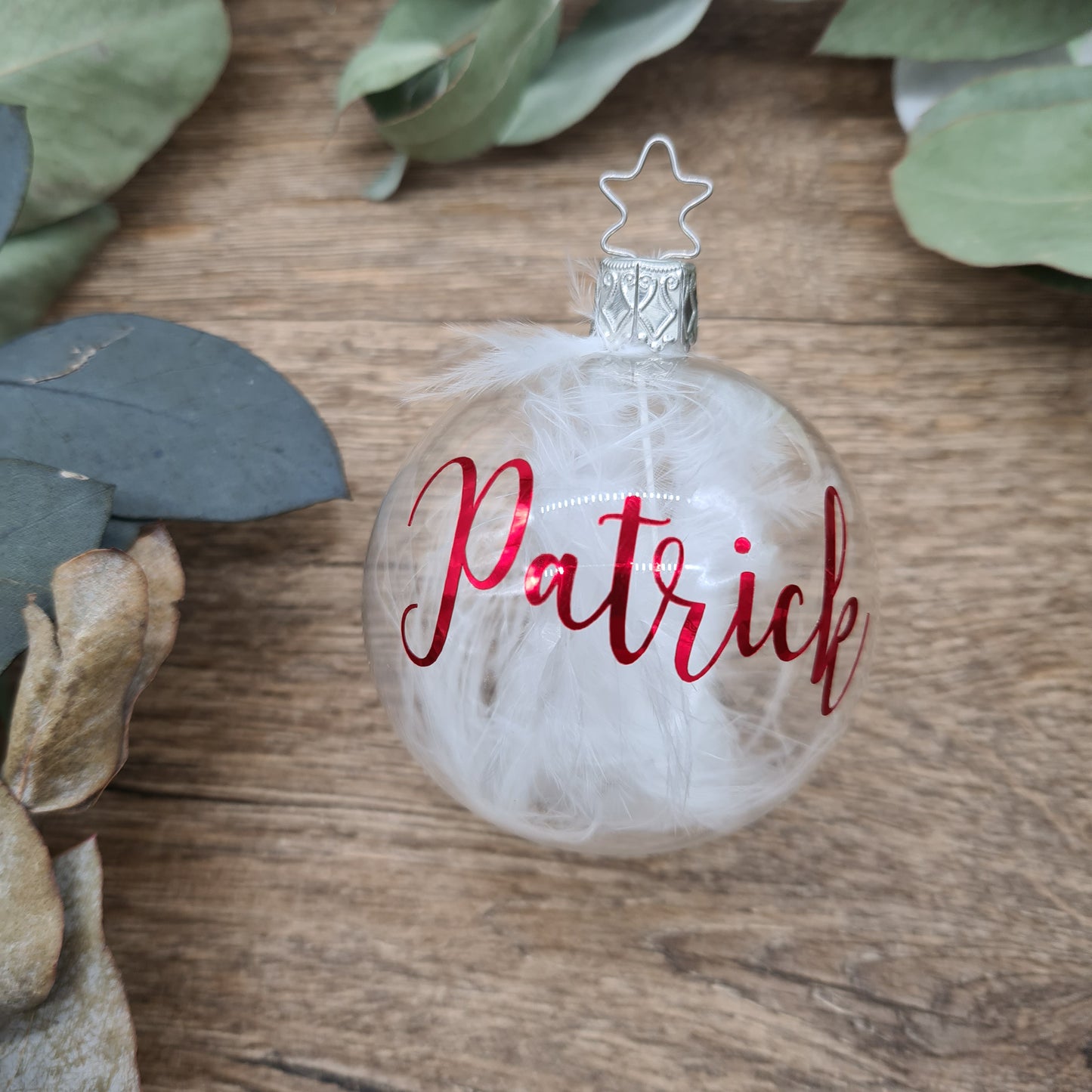 Klares mundgeblasenes Glas, gefüllt mit weißen Federn und personalisiert mit metallischem Rot