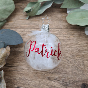 Clear blown glass filled with white feathers and personalized with metallic red
