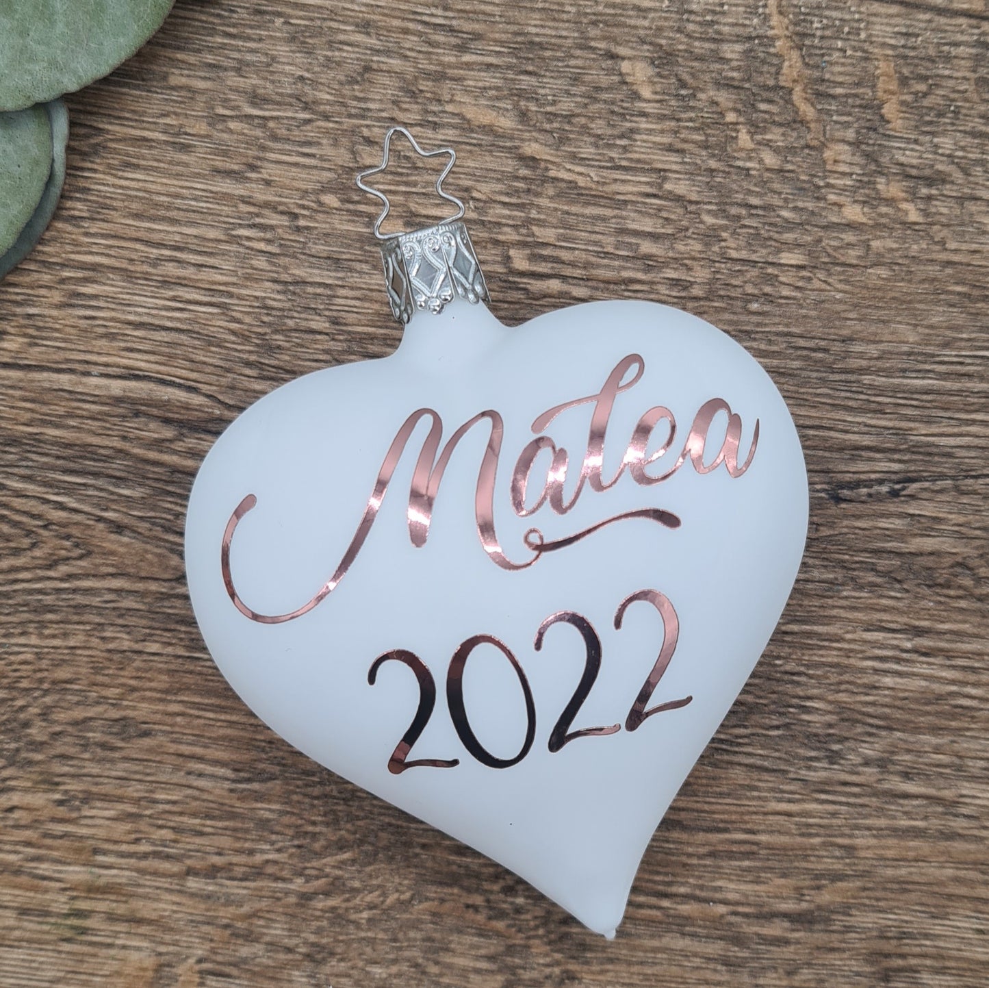Babys 1. Weihnachten, Personaliserung auf einem herzförmigen Glasornament, weiß-matt mit Roségold Text.